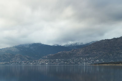 Scenic view of lake by mountains against sky