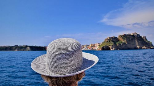 Rear view of woman in hat against sea