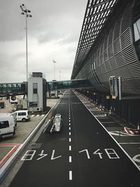 Cars on road in city against sky