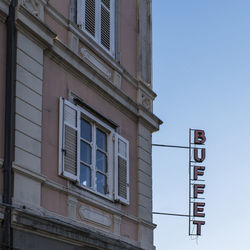 Low angle view of text on building against clear sky