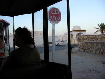 Rear view of woman standing on road against sky