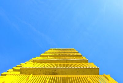 Low angle view of yellow balconies against blue sky