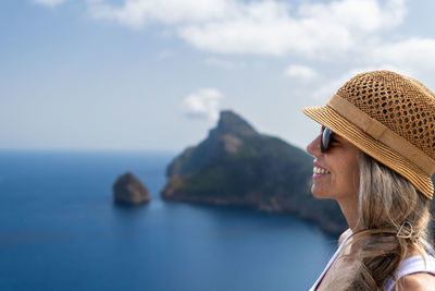 Side view of woman looking at sea against sky