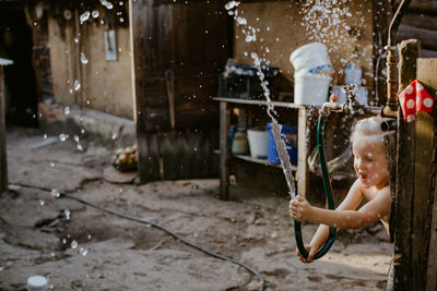 Rear view of smiling girl holding umbrella