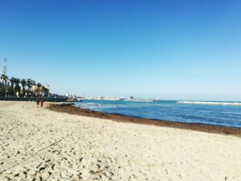 Scenic view of beach against clear blue sky