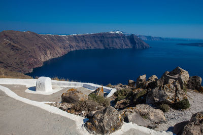 Panoramic view of sea and rocks against blue sky