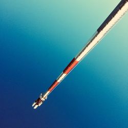 Low angle view of crane against clear blue sky