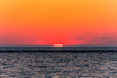 Scenic view of sea against orange sky