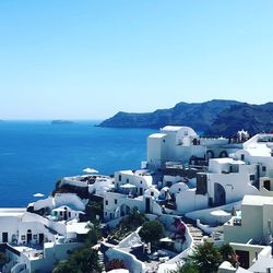 High angle view of buildings by sea against clear sky