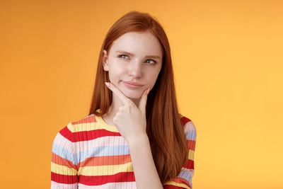 Portrait of a beautiful young woman over yellow background