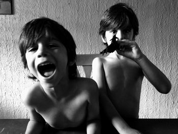 Portrait of twin boys screaming at home