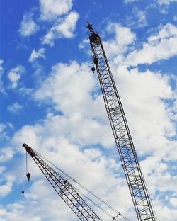 Low angle view of crane against cloudy sky