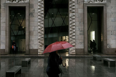 Reflection of woman on wet umbrella in rainy season