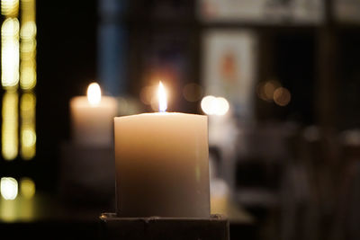 Close-up of candles burning in illuminated building