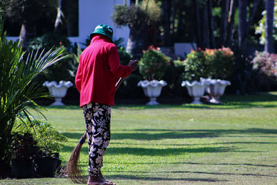 Girl sweeping on field in garden