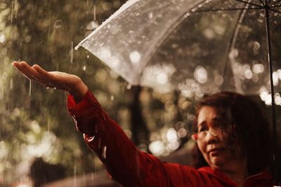 Woman holding umbrella during rainy season