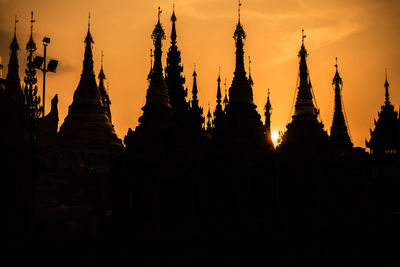 Silhouette of temple building against sky during sunset