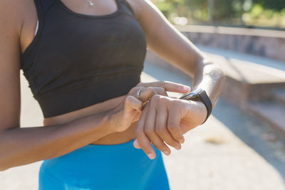 Young sportswoman checking smart watch