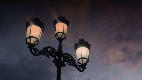 Low angle view of illuminated street light against sky