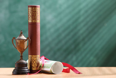 Close-up of trophy with diploma on desk