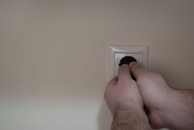 Close-up of hand on wall at home