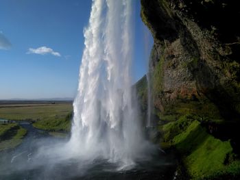 Idyllic shot of waterfall against sky