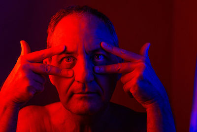 Portrait of man wearing mask against black background