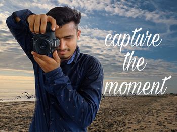 Young man photographing while standing on land