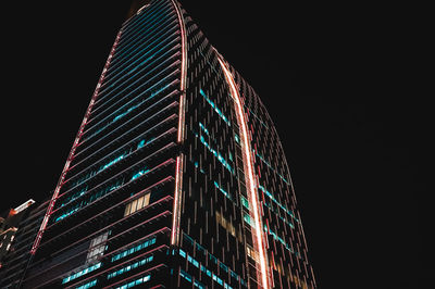 Low angle view of illuminated building against sky at night