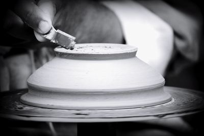 Close-up of person preparing tea cup