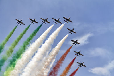 Low angle view of airplanes flying against sky