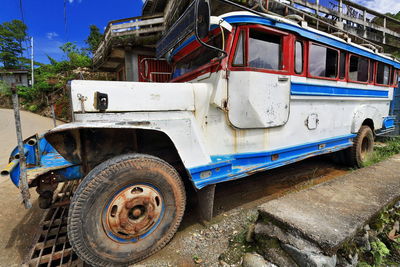 Old abandoned car on street in city