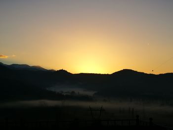 Scenic view of silhouette mountains against sky at sunset