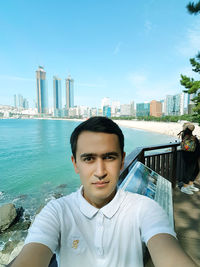 Portrait of young man against cityscape