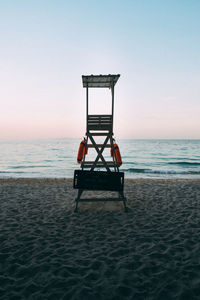 Lifeguard chair on beach against clear sky