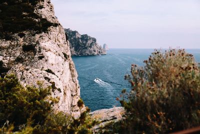 Scenic view of rocks in sea against sky