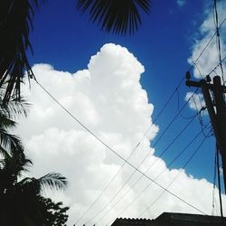 Low angle view of power lines against cloudy sky