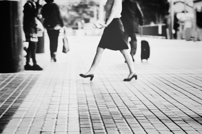 Low section of woman walking on zebra crossing