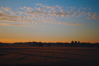 Scenic view of field against sky during sunrise