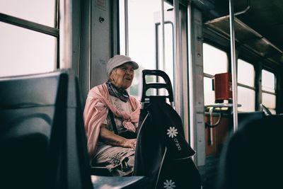 Rear view of woman looking through window