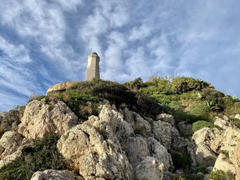 Low angle view of rocks on mountain against sky