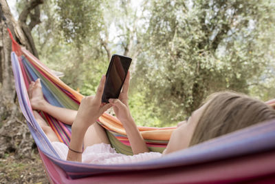 Side view of woman lying on hammock