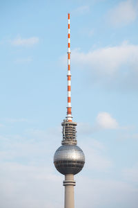 Low angle view of fernsehturm against cloudy sky