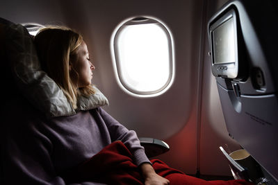 Midsection of woman sitting in airplane