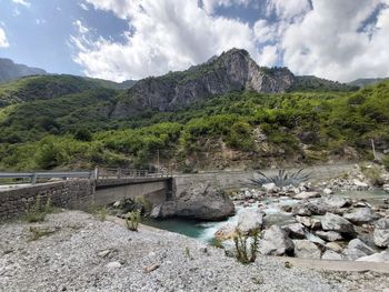 Scenic view of river by mountains against sky