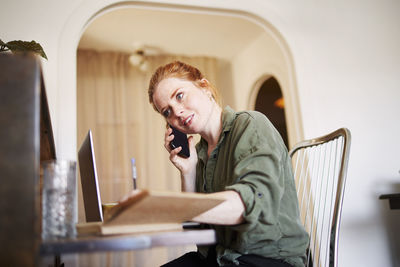 Woman at home talking via cell phone