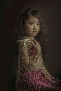 Portrait of a beautiful young woman over black background