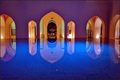 Reflection of illuminated building on swimming pool at night