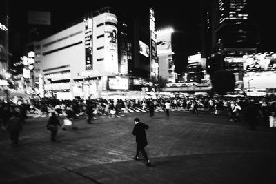 Woman standing in illuminated city at night