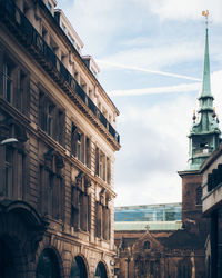 Low angle view of buildings against cloudy sky